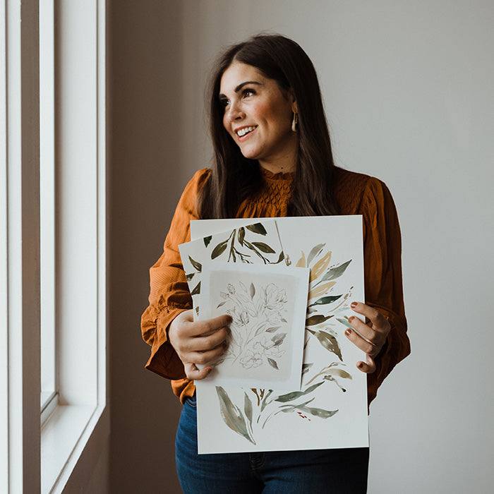 artist Julie Murray holding some of her artwork