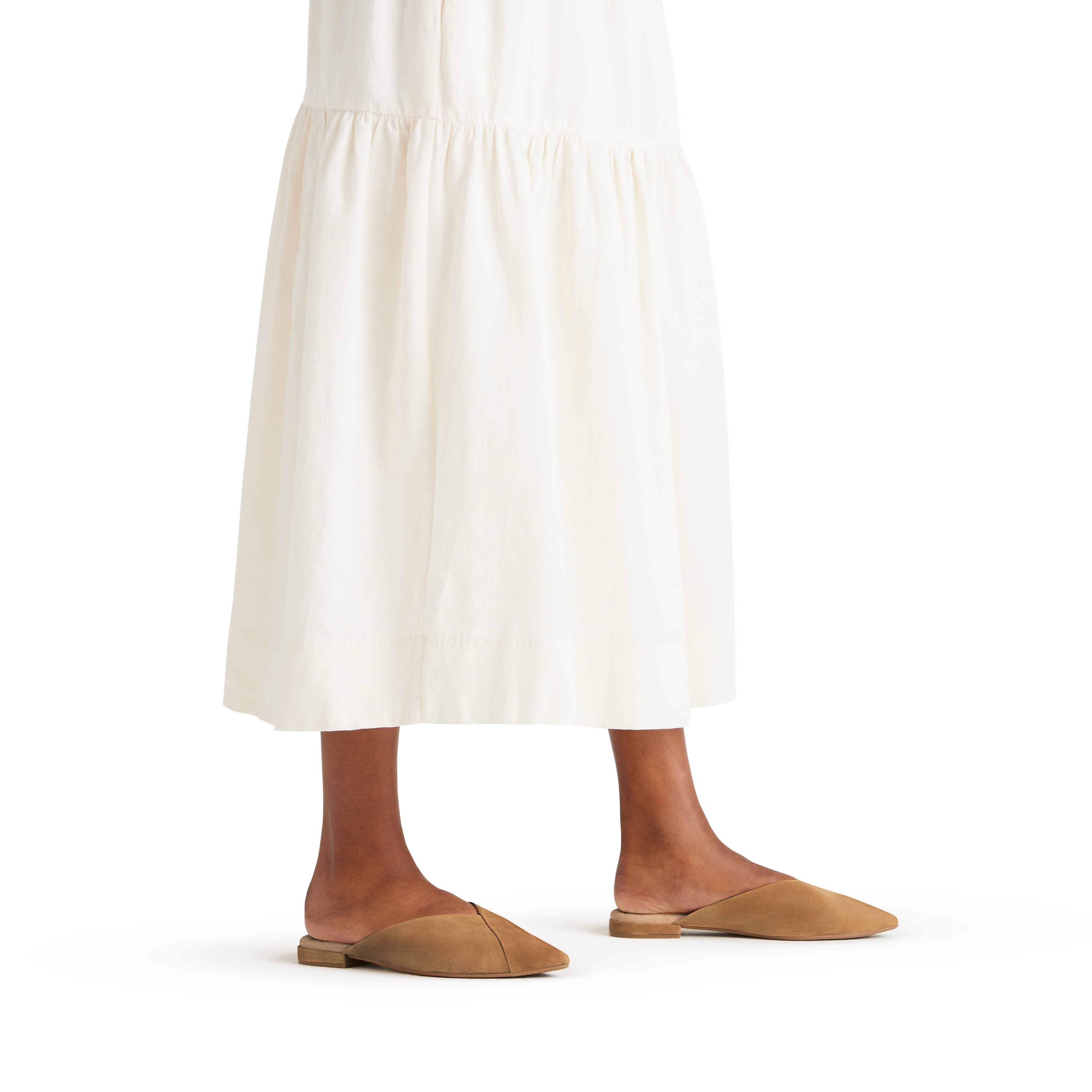 on figure side view of the Swan mule in Golden Oak (tan) Suede