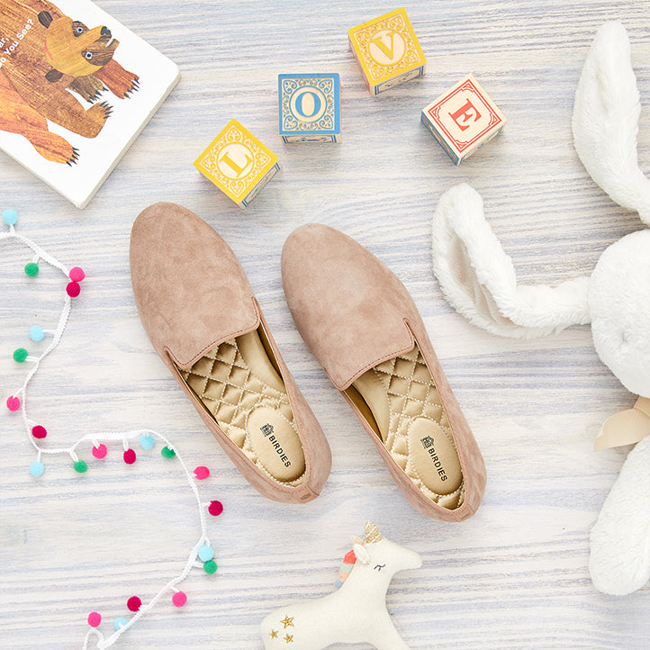 Birdies Starling flats in latte on wood floor with children’s toys