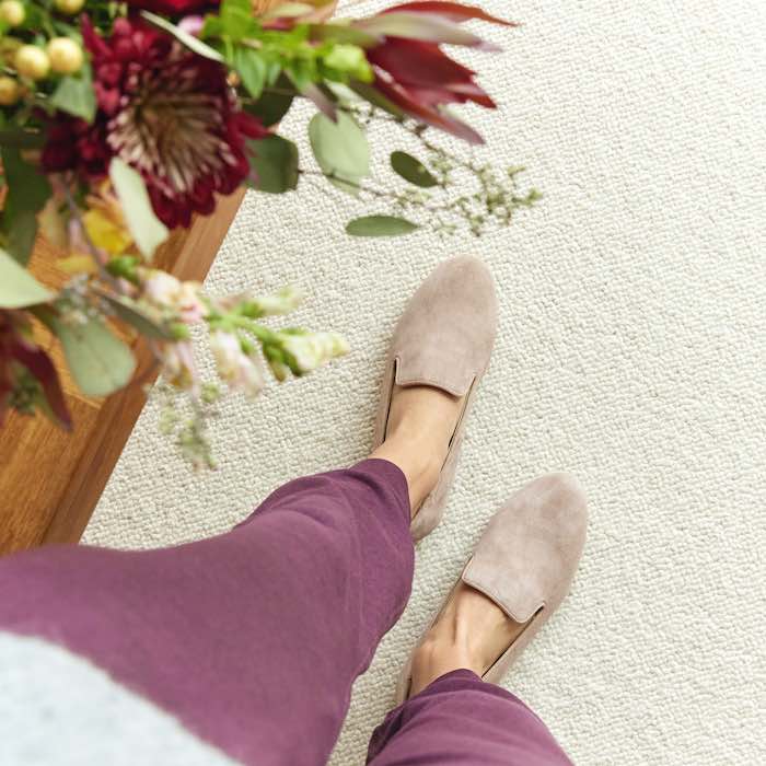 Image Alt: woman wearing beige suede flats and maroon jogger pants