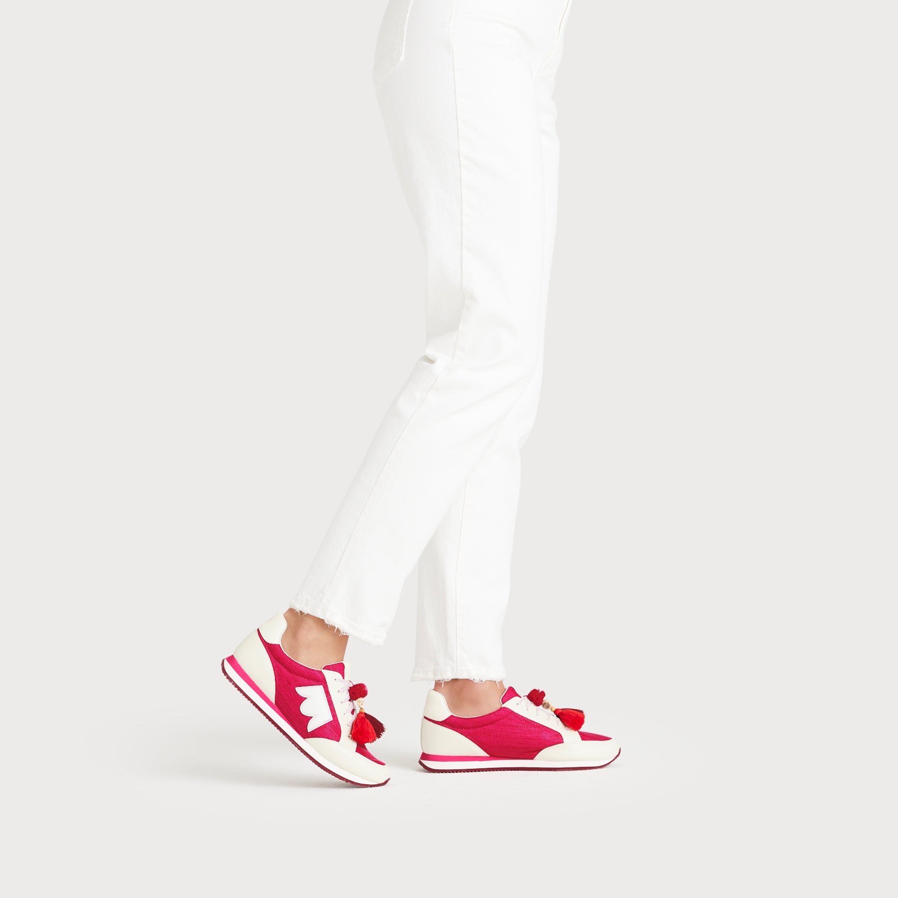 on figure side view of the Roadrunner Sneaker in Hibiscus (pink)
