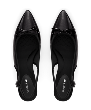 hover | Black patent leather slingback kitten heel with pointed toe and delicate bow detail, featuring a glossy finish. Top view.