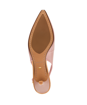 Pink patent leather slingback kitten heel with pointed toe and delicate bow detail, featuring a glossy finish. Bottom view.