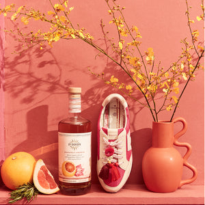 top view of the Roadrunner Sneaker in Hibiscus (pink) with 21 seeds Grapefruit Hibiscus Blanco Tequila Bottle 