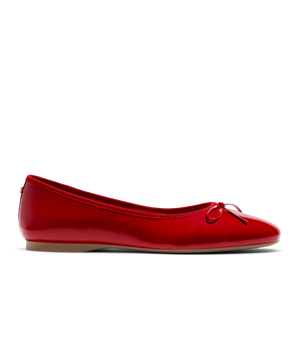 Red patent leather ballet flat with delicate bow detail, featuring a glossy finish. Side view.